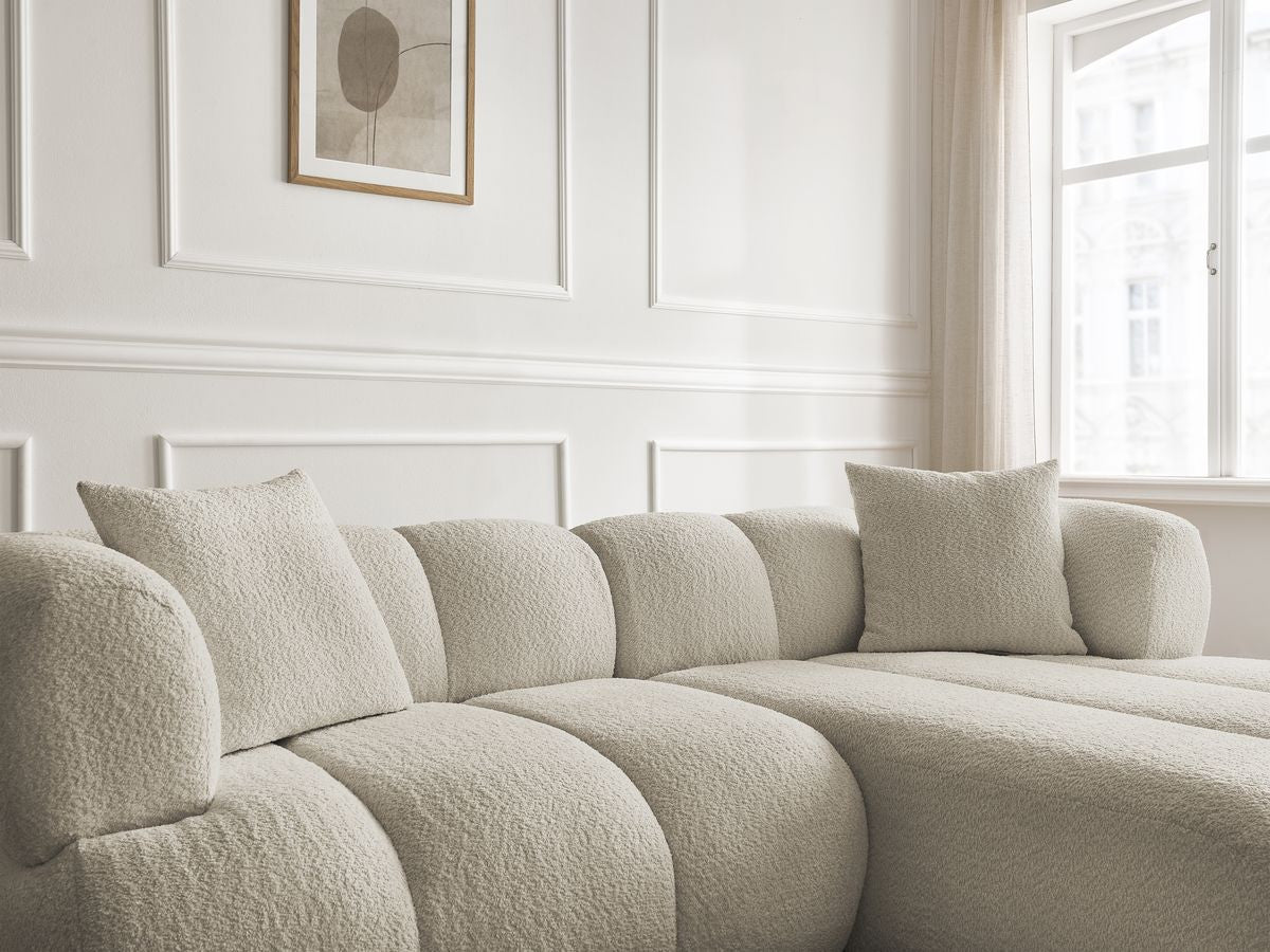 Hjørnesofa PAMIRA i bouclé-stoff med puff