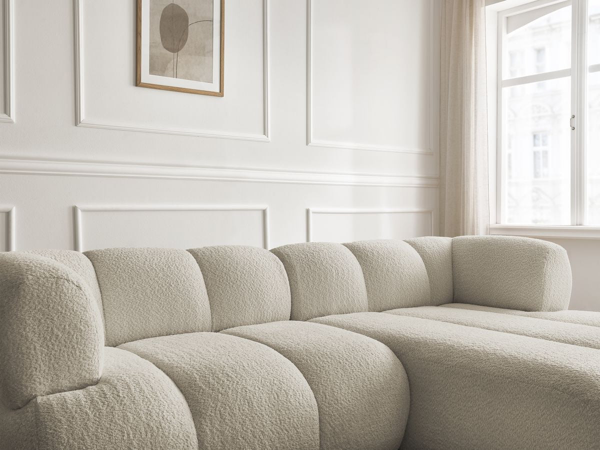 Hjørnesofa PAMIRA i bouclé-stoff med puff